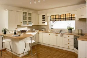 00 white fitted kitchen with hanging cabinets and light brown worktops