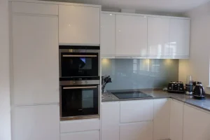 Variouspics184-1920w L-shaped fitted kitchen with white glossy cabinets and gray worktops