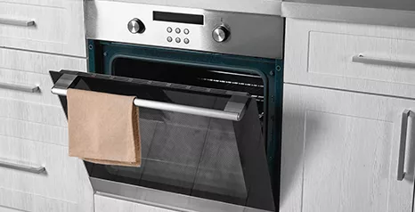 oven with partially opened door with cloth hanging on its handle